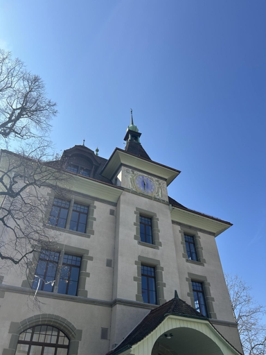 Vista dal basso di un edificio imponente in stile architettonico alpino contro un cielo azzurro 