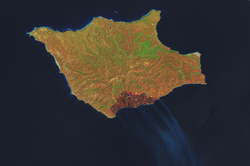 L’incendio è stato avvistato per la prima volta da alcuni aerei il 15 maggio 2026 ed è stato confermato quella stessa mattina dal National Park Service. Il satellite Landsat 9 ha catturato queste immagini il giorno seguente, quando l’area bruciata aveva raggiunto 5.690 acri (2.300 ettari). Entro il 19 maggio, il fuoco aveva devastato circa 16.600 acri (6.700 ettari), inclusa gran parte del quadrante sud-orientale dell’isola. Il perimetro dell’incendio risultava ancora non contenuto.

L’immagine in falsi colori è composta da lunghezze d’onda che attraversano il fumo per rivelare l’area bruciata (in marrone scuro). La firma infrarossa del fronte di fuoco attivamente in combustione appare in arancione. La seconda immagine mostra la stessa area a colori naturali, così come la vedrebbero gli occhi umani, con il fumo che si riversa sull’Oceano Pacifico.

Secondo funzionari e resoconti giornalistici, l’incendio sarebbe stato causato dall’uomo, anche se gli investigatori stavano ancora cercando di determinare le circostanze esatte dell’evento. In base alle notizie riportate dai media, il fuoco ha bruciato vicino a una popolazione di pini di Torrey, un raro tipo di pino che negli Stati Uniti cresce naturalmente solo su Santa Rosa Island e nei pressi di San Diego.
