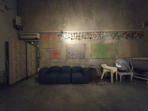 Interno del locale Clandestino di Faenza. È presente un divano blu appoggiata a una parete tinteggiata con colori abbastanza scuri tra il divano ci sono dei quadri.