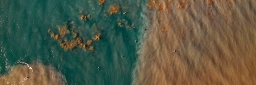 Surfisti travolti da un'onda marina oscura.