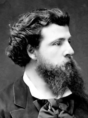 Ritratto fotografico in bianco e nero di Edouard Pailleron. Uomo giovane, con capelli lunghi pettinati all'indietro, lunga barba riccioluta suddivisa in due; indossa una giacca e una camicia bianca con un fiocco da artista