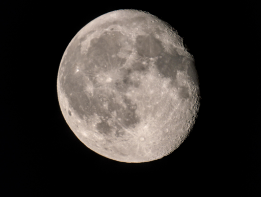  L'immagine mostra la Luna piena, con un dettaglio ravvicinato che evidenzia la sua superficie craterata. La Luna è rappresentata in tutta la sua grandezza, con una luminosità che contrasta nettamente con lo sfondo nero dello spazio. La superficie lunare è caratterizzata da numerose macchie e crateri, tra cui si distinguono chiaramente il Mare Imbrium e il cratere Tycho Brahe. La luce solare illumina la superficie, creando ombre che accentuano la topografia. La Luna appare quasi perfettamente circolare, con una leggera sfumatura di colore grigio chiaro.