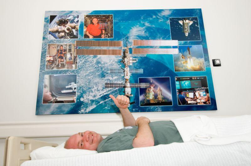 IT: foto del 2004 di un partecipante allo studio Science for Bed-Rest della NASA.
Notate la Stazione Spaziale Internazionale non ancora terminata.
Crediti: NASA Glenn Research Center su LinkedIn.

EN: a 2004 photo of a NASA Science for Bed-Rest study test subject.
Note that the International Space Station was still unfinished.
Credit: NASA Glenn Research Center on LinkedIn.
