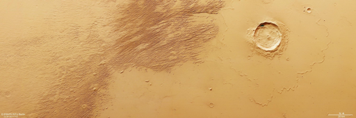 La sonda Mars Express dell’ESA ha osservato le tracce lasciate dai venti marziani che sollevano granelli di sabbia e agiscono come una sabbiatrice cosmica, scavando lunghi canali intervallati da creste — note come yardang — vicino all’equatore di Marte. Questa porzione di terreno si trova all’estremità settentrionale dei monti Eumenides Dorsum; queste montagne si estendono ben oltre il margine dell’immagine verso ovest della regione vulcanica di Tharsis e fanno parte della Medusae Fossae Formation.
