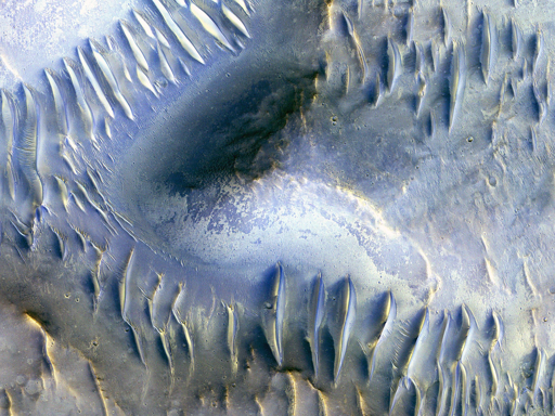 Dune più piccole corrono perpendicolarmente ad alcune delle dune di scala maggiore, probabilmente indicando un cambiamento nella direzione dei venti in quest’area.

Anche se può essere difficile accorgersene, questo gruppo di dune si trova molto vicino alla fossa centrale di un cratere da impatto largo 35 chilometri. I dati di altri strumenti indicano la presenza di materiali simili all’argilla nella roccia esposta nella fossa centrale.