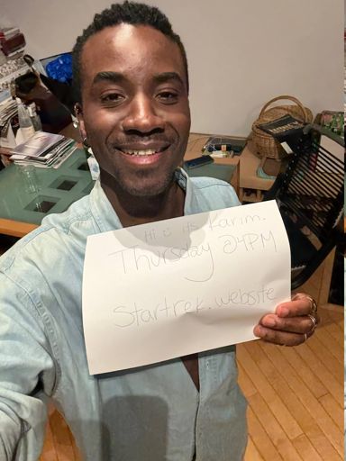 Karim Diané holding a piece of paper that says "startrek.website" thursday @ 4pm"