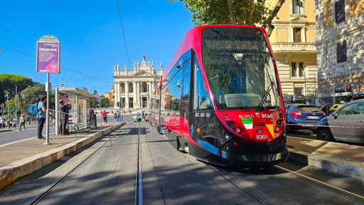 Immagine del nuovo tram CAF Urbos durante le prove sulla rete tranviaria di Roma. Il convoglio, identificato con il numero 9301, percorre la rete senza passeggeri nell’ambito dei collaudi necessari prima dell’entrata in servizio. Il mezzo presenta la nuova livrea e le caratteristiche dei tram destinati al rinnovo della flotta tranviaria romana. Sullo sfondo è visibile il contesto urbano della Capitale.