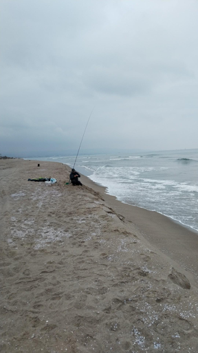 Pescatore in ginocchio dinnanzi al mare