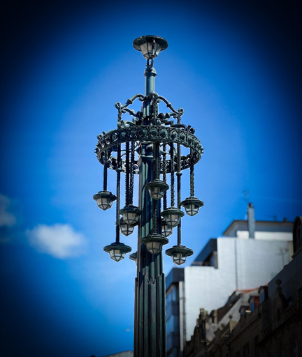 Lampione decorativo in metallo sotto un cielo blu luminoso.