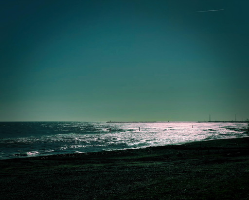 Spiaggia al tramonto con riflessi luminosi sull'acqua