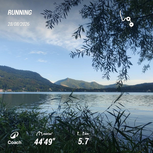 Foto quadrata con le statistiche della corsa in sovraimpressione: durata 44'49"; distanza 5,7km.
La foto mostra il lago al tramonto (sole alle spalle). La metà superiore è occupata dalle montagne all'orizzonte. Il cielo azzurro ha leggere velature bianche che iniziano a tingersi di rosa.