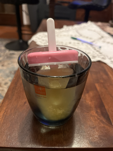 Bicchiere d’acqua con un ghiacciolo di succo di mela affogato in essa 