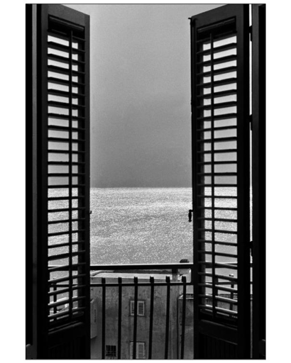 BW pic, view of the sea from a balcony wirh open door.