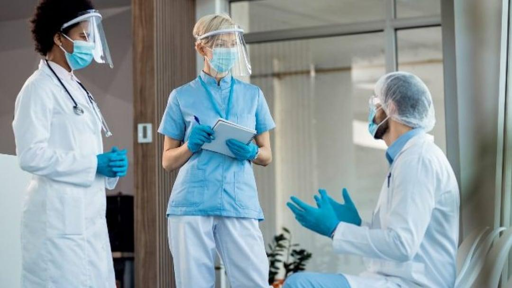 Nella fotografia, tre infermieri dotati di strumenti sanitari per emergenza pandemica.