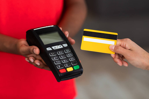 Un dispositivo POS a cui viene avvicinata una carta di credito