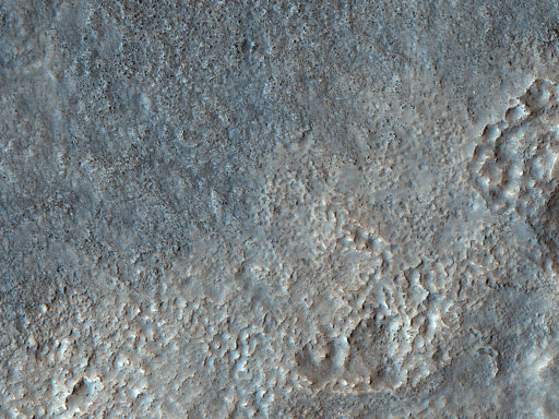 Grazie alla risoluzione della telecamera HiRISE, possiamo vedere che il motivo per cui un lato del confine appare più scuro dell’altro è dovuto alla presenza di numerosi massi sparsi sulla superficie del lato più scuro.