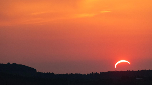 Eclissi del 12 agosto 2026 al tramonto. Arco di fuoco sopra una collina con alberi in ombra. Zona di scatto: colline intorno a Montespertoli (provincia di Firenze). Sulla sinistra della foto il colle di Montecastello, zona Botinaccio (comune di Montespertoli)