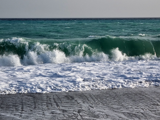 Mare mosso con onde "verdi" che si arrotolano mentre si avvicinano alla spiaggia