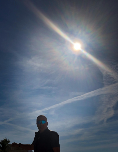 Una persona ( a caso😀) con occhiali da sole, in controluce sotto un cielo azzurro
