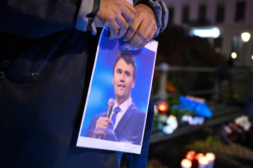 Un uomo tiene in mano una foto di Charlie Kirk durante una veglia con la scritta "In memoria di Charlie Kirk, per la libertà, il patriottismo e la giustizia" davanti all'ambasciata degli Stati Uniti dopo che l'attivista di destra statunitense, commentatore, Charlie Kirk, alleato del presidente degli Stati Uniti Donald Trump, è stato ucciso a colpi d'arma da fuoco durante un evento nella Utah Valley.