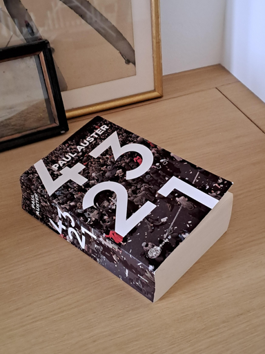 La foto mostra il libro "4 3 2 1" di Paul Auster nella sua ultima edizione per Einaudi.