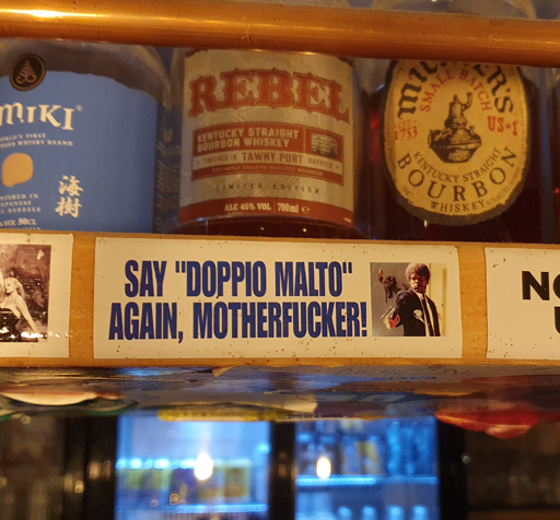 Adesivo attaccato al bancone di un pub che serve birre artigianali con scritto:"Say "Doppio Malto" Again, Motherfucker! (e la foto del personaggio iconico delle Iene di Tarantino)