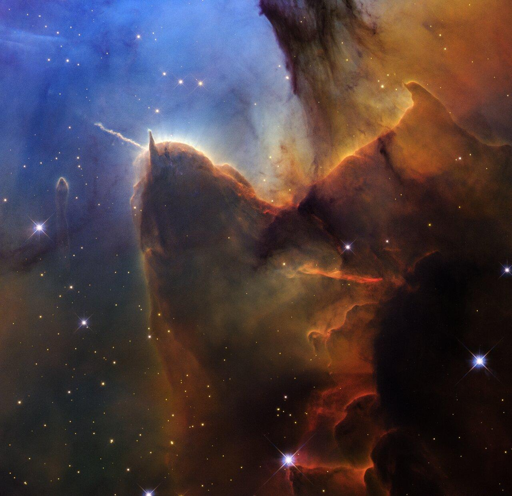 La visione di Hubble della Trifid Nebula (nota anche come Messier 20 o M20) si concentra su una “testa” e un “corpo” ondulato di una nube di gas e polveri color ruggine che ricorda un limone di mare, o lumaca marina, che sembra scivolare attraverso il cosmo.

Il “corno” sinistro del Limone di mare cosmico fa parte di Herbig-Haro 399, un getto di plasma espulso periodicamente nel corso dei secoli da una giovane protostella situata nella “testa” della struttura.

Osservando il getto espandersi, i cambiamenti rilevati permettono ai ricercatori di misurare la velocità dei flussi e determinare quanta energia la protostella sta immettendo in queste regioni, offrendo indizi su come le stelle appena nate interagiscono con l’ambiente circostante.

Subito in basso a destra si trova la prova del controgetto: linee frastagliate arancioni e rosse che “scendono” lungo il retro del “collo” del limone di mare, dove nella polvere marrone appare una naturale forma a V....


