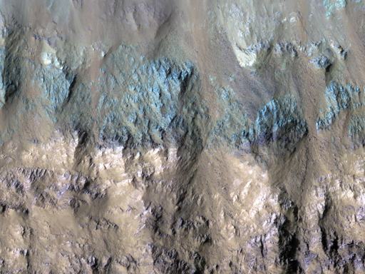Questa immagine mostra un cratere sul fondo di Eos Chasma, parte del sistema di canyon Valles Marineris su Marte. I crateri marziani sono molto utili per i geologi, perché forniscono sezioni trasversali del sottosuolo.

Il muro sud del cratere mostra evidenze di diversi tipi di rocce, con colorazioni differenti.

Nelle parti in bianco e nero dell’immagine, sembrano esserci due tipi principali di roccia: una relativamente chiara e una scura. Tuttavia, nella striscia a colori larga 1,1 km, le rocce scure si rivelano più complesse, alcune con una sfumatura verdastra e altre violacea.

Nota: questi non sono i colori che l’occhio umano percepirebbe se si fosse sul posto! Nei colori migliorati, i dati infrarossi vicini di HiRISE appaiono rossi, il rosso è mostrato come verde e i dati blu-verde come blu, permettendo di visualizzare più informazioni contemporaneamente.