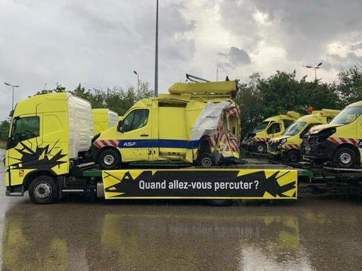 Carro attrezzi che trasporta un veicolo del soccorso stradale incidentato. Sulla destra si vedono altri 4 veicoli simili, anche loro incidentati
Sul lato del carro attrezzi c'è il motto della campagna: "Quand allez-vous percuter?" (tradotto: "Quando hai intenzione di colpire? ”)